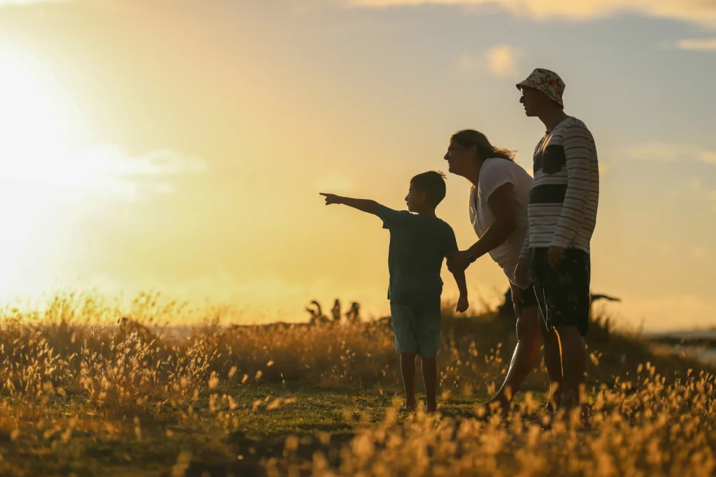 Silhouette d'une famille admirant le coucher de soleil dans la nature.
